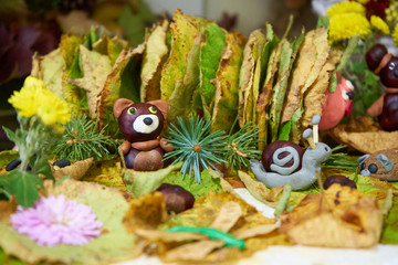 autumn applique,autumn baby craft in kindergarten, snail made of plasticine on yellow leaves