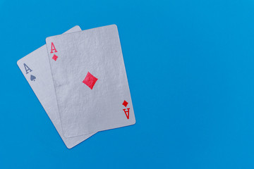 Pocket aces (pair) hand on bright blue flat lay background for poker, betting and casino concepts