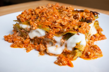Close up of homemade Italian style green lasagna made with meat sauce and mozzarella cheese