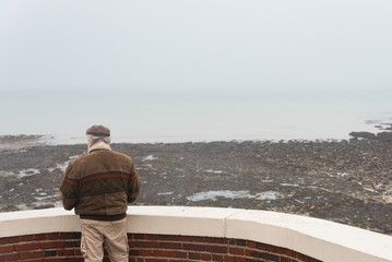 un homme de dos regarde la mer