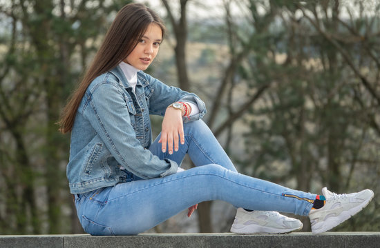 Happy young woman sittnig on the wall