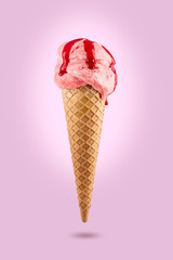Strawberry ice cream cone with icing on colored background