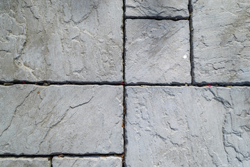 Textured grey concrete garden paving slabs of different sizes beautifully laid out. Image was taken on a warm sunny day, mid to late afternoon.
