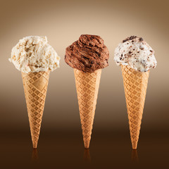 Ice cream cones with different flavors on brown background