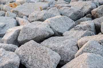 Close up. rock stone breakwater at the pier on the beach.