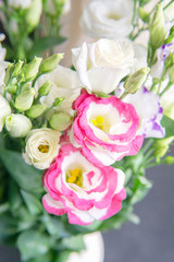 Floral background, beautiful morning light. Bouquet of white, purple and pink eustoma flowers in white vase. Copy space. Valentines Day, Mothers Day, birthday celebration concept. Greeting card.