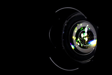 Lense flare lights on shutter. Reflection on photo, video camera on black background. Sunlight abstract bokeh in digital macro studio shot.