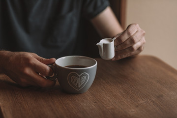gray cup of coffee and a cup of milk on a wooden table