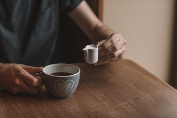 gray cup of coffee and a cup of milk on a wooden table