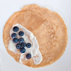 Delicious pancake made from spelt flour with cream and blueberries