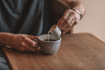 gray cup of coffee and a cup of milk on a wooden table