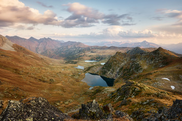 Beautiful mountains at sunset, gold alpine field, lakes and mountain ranges, travel and mountain life