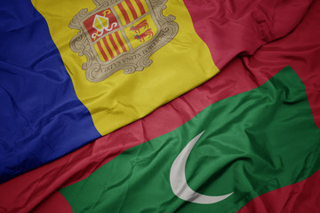 waving colorful flag of maldives and national flag of andorra.