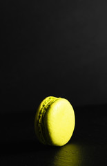 sweets advertising concept, french dessert - pistachio macaroon on a black background, close-up