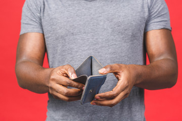 Poverty crisis concept. Upset african american young bearded man in casual holding empty wallet...