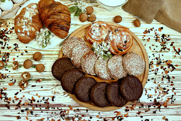 Scene with an assortment of pastries, original Nuremberg gingerbread cookies, rolls, croissants with ingredients. Top view over a wooden textured white background.Coffee shop advertising concept