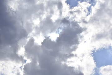 Sonne versteckt sich hinter grauen Wolken am Himmel