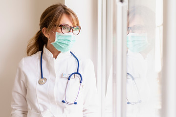 Stressed female doctor portrait while wearing face mask in the hospital