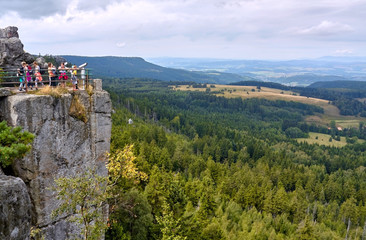 Fototapeta na wymiar Tourists admiring view from viewing terrace atop Szczeliniec Wielki peak in Table Mountains, Poland