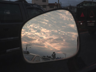 Fototapeta na wymiar Cielo al amanecer por el espejo del auto