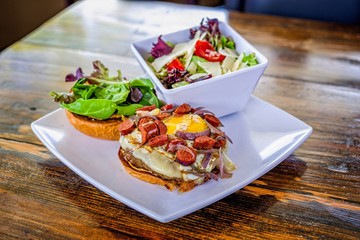Open faced sandwich and salad plate on white, restaurant style culinary.