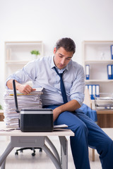 Young male employee making copies at copying machine