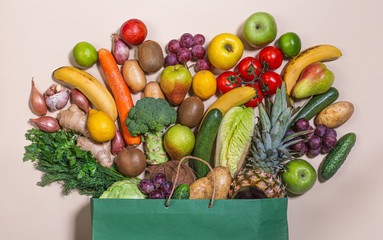 Grocery, paper bag with healthy, different fruits and vegetables on a light background. The concept of a grocery supermarket. Healthy eating Vegan. Flat ley
