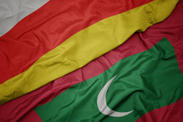 waving colorful flag of maldives and national flag of south ossetia.