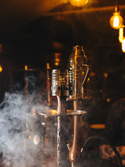 A pair of hookahs in a swirl of sweet smoke, warm and relaxed vibe