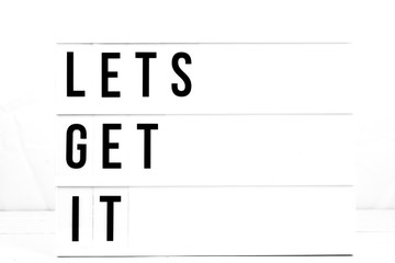 Inspirational Lets Get It quote on vintage retro board. Concept. flat lay