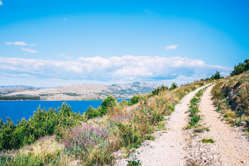 Mountain path with sea view. Hiking trail with beautiful Mediteranean seacape. Active lifestyle concept. Road trip with seascape view over Adriatic coast. Active vacation concept. Background with copy