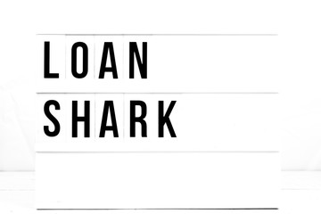 Loan Shark Warning sign on Vintage Retro Board. Business Flat Lay