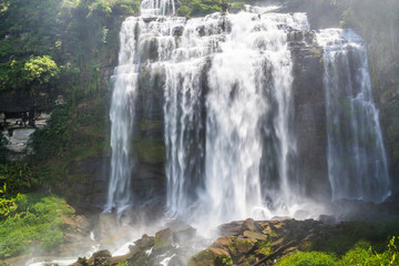 Flowing water of large and high waterfall on mountain cliff in the tropical rain forest. Beautiful nature waterfall in Bolaven Plateau, southern Laos, Tad kamud waterfall