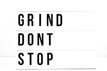 Inspirational Grind Don't Stop quote on vintage retro board. Concept. flat lay