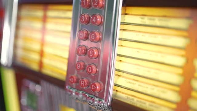 The inside parts and red number buttons with songs of a retro and vintage american fifties juke box in close up with a shallow depth of field.