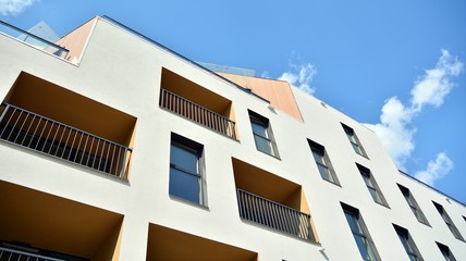Contemporary residential building exterior in the daylight. Modern apartment buildings on a sunny day with a blue sky. Facade of a modern apartment building