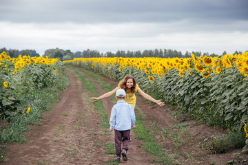 Mother and son spend time in a field of sunflowers.