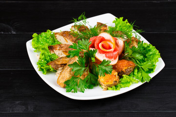 cooked meat mix of chicken wings and legs, chicken fillet with herbs and parsley, grapefruit on a white plate. wooden table background