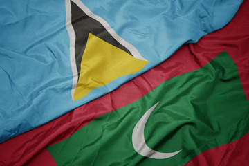 waving colorful flag of maldives and national flag of saint lucia.