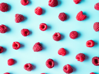 Pattern of ripe red raspberry on blue background. Organic raspberries creative layout. Top view or...