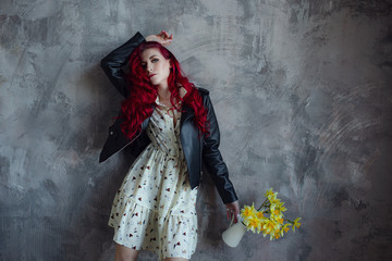 young beautiful red haired woman with yellow daffodils