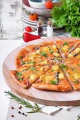 Round pizza with anchovies, mozzarella cheese and tomato sauce garnished with fresh parsley on white table