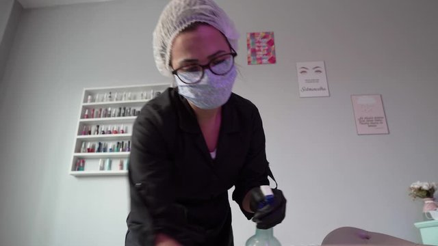 beautician Sanitizing and disinfecting working area surfaces against coronavirus, Covid-19 and bacteria
