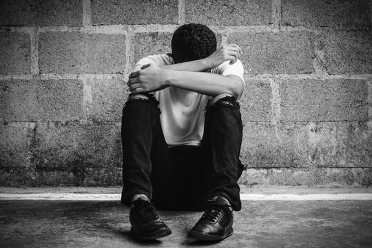 decepci&oacute;n de un hombre sentado en el piso tap&aacute;ndose la cara de tristeza.