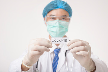 Doctor is holding Covid-19 card on white background