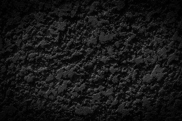 Black cement wall with ragged and dirty surface texture. The old and broken rough dark concrete wall background.