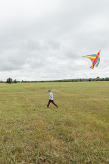 A boy launches a kite on the field.