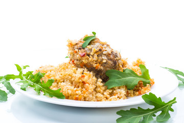 boiled bulgur groats with vegetables and meatballs in a plate