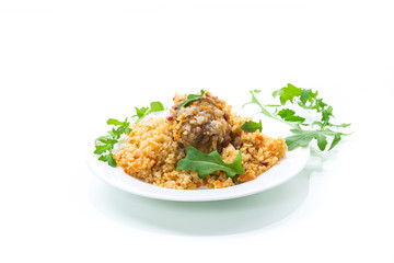 boiled bulgur groats with vegetables and meatballs in a plate