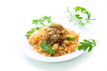 boiled bulgur groats with vegetables and meatballs in a plate
